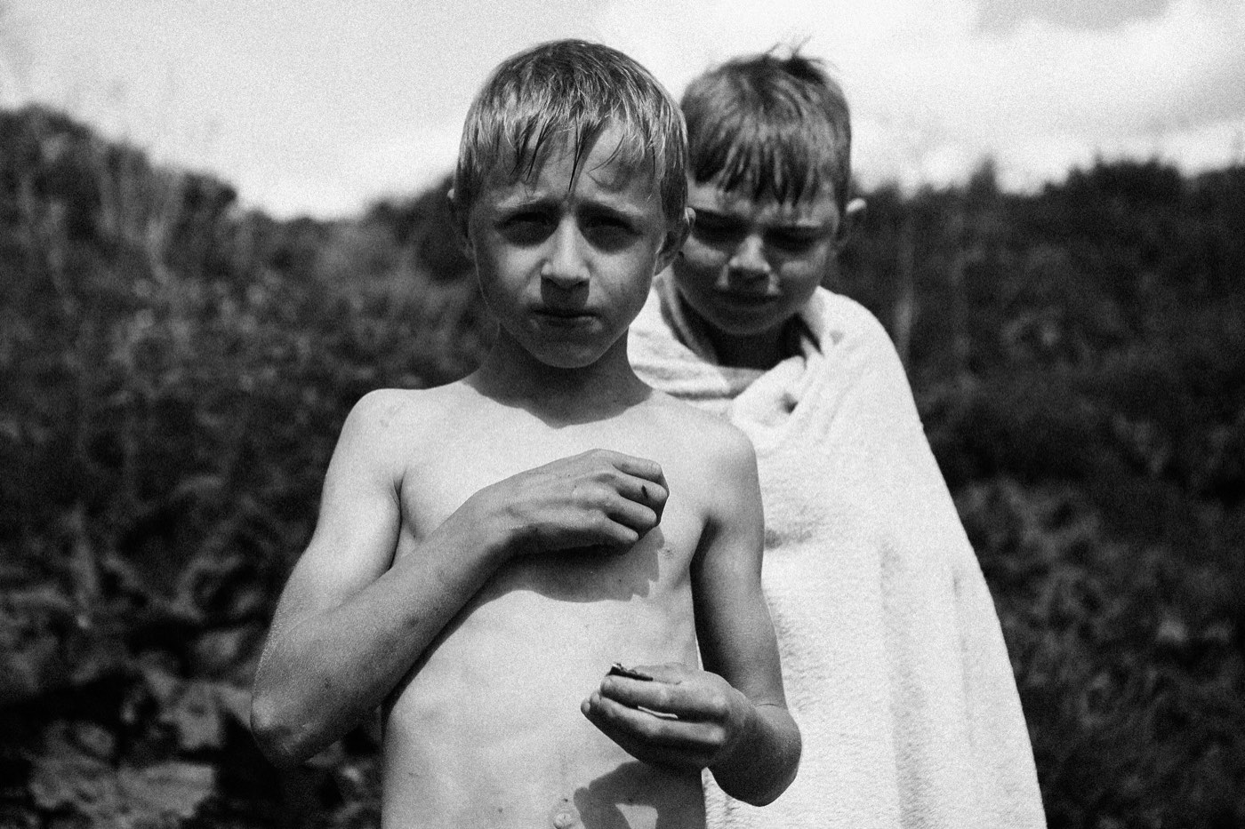 Чёрно-белый плёночный кадр: двое мальчишек, один закутан в полотенце